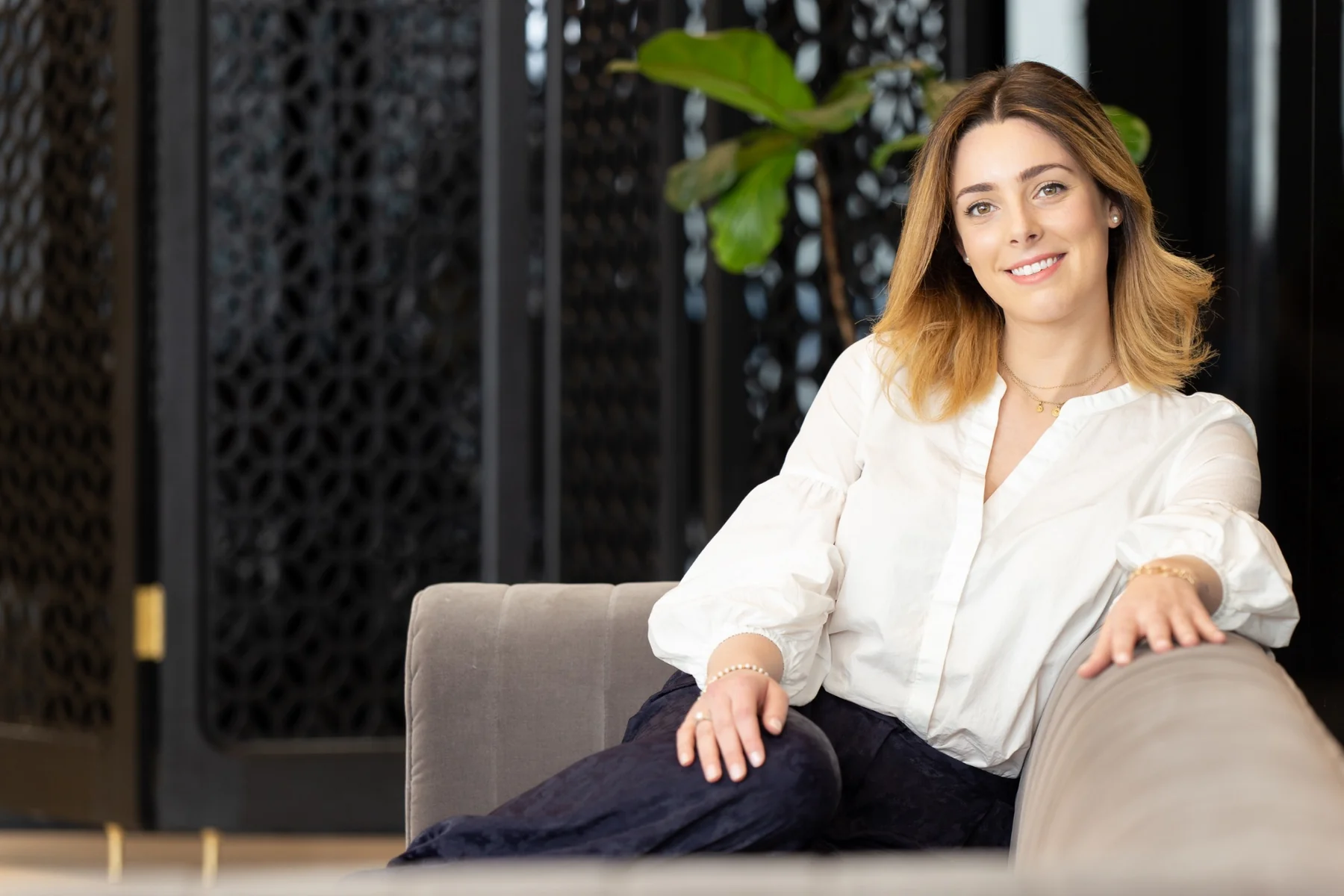 Professional lifestyle portrait of a woman seated in a contemporary interior